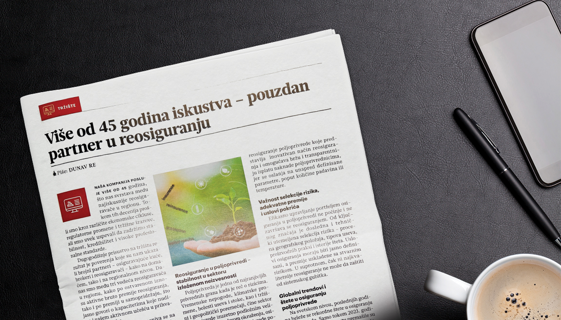 An open magazine, a cup of coffee, mobile phone, and ballpoint pen on a black surface